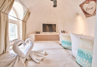 Comfortabele glampingaccommodatie in Iglu Camp Tangermünde, Saksen-Anhalt, met stijlvolle bed en decor.