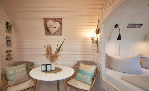 Intérieur confortable d'une cabane igloo avec coin salon, table et lit, glamping à Tangermünde.