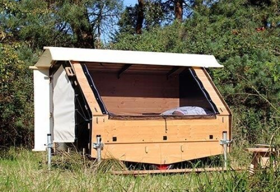 Hébergement glamping nommé 'Uhlenköper-Camp Uelzen - Slaapmand Nedersaksen' dans la nature avec une cabane en bois.