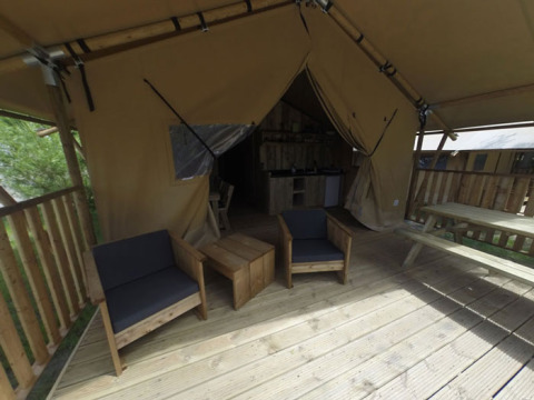 Veranda in legno con poltrone davanti a una tenda glamping presso Campingpark Rerik - Glamping Rerik, Germania.