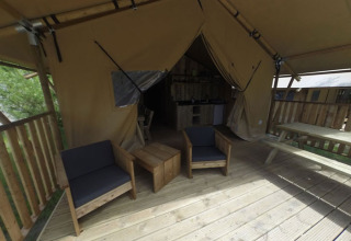 Terrasse en bois et mobilier devant une tente glamping au Campingpark Rerik - Glamping Rerik, en Allemagne.