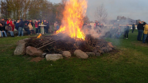 People gather around a large bonfire at Campingpark Rerik - Glamping Rerik, enjoying the outdoor atmosphere.