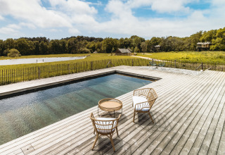 Houten terras met zwembad en rotanstoelen bij Dihan Evasion - Lodges Bretagne, glamping midden in de natuur.