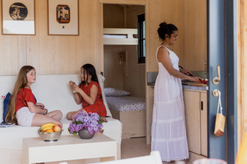 Intérieur de l’hébergement glamping 'Dihan Evasion - Lodges Bretagne' avec deux filles et une femme en cuisine.