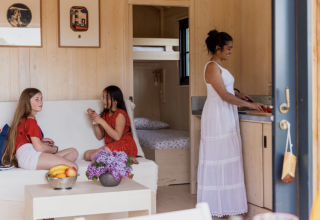 Interieur van glampingaccommodatie 'Dihan Evasion - Lodges Bretagne' met twee meisjes en een vrouw in de keuken.