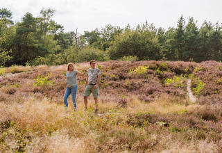 Stel wandelt door de heide bij Vakantiepark Ommerland – Safaritenten Overijssel in de natuur.