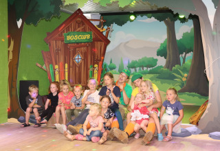 Kinderen en volwassenen genieten samen voor het Boscub-hutje in de speelzone van Ommerland glamping.