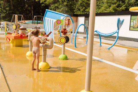 Kindje speelt op een watertoestel tijdens een zonnige dag op Vakantiepark Ommerland Safaritenten Overijssel.