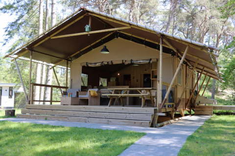 Glamping accommodatie bij Vakantiepark Ommerland – Safaritenten Overijssel, met open veranda in het bos.