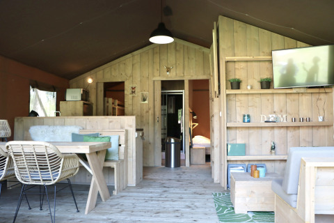 Interior de una tienda safari en Vakantiepark Ommerland, Overijssel, con muebles de madera y decoración acogedora.