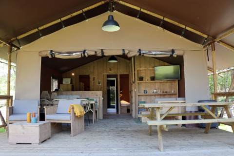 Glamping-Unterkunft bei Vakantiepark Ommerland – Safaritenten Overijssel mit Holzterrasse und gemütlicher Einrichtung.