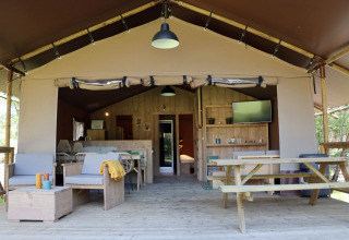 Hébergement glamping au Vakantiepark Ommerland – Safaritenten Overijssel avec terrasse en bois et mobilier confortable.