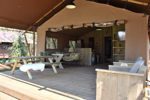Glamping accommodatie in safaritent bij Vakantiepark Ommerland, Overijssel, met houten meubels en veranda.