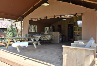 Glamping accommodatie in safaritent bij Vakantiepark Ommerland, Overijssel, met houten meubels en veranda.