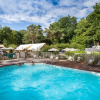 Outdoor pool at Huttopia Douarnenez – Glamping Bretagne, surrounded by loungers and lush green forest scenery.