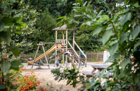 Speeltuin te midden van groen bij Huttopia Douarnenez – Glamping Bretagne, gezinsvriendelijke campinglocatie.