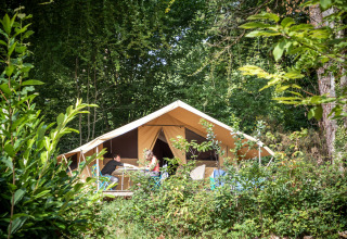 Glamping accommodatie bij Huttopia Douarnenez – Glamping Bretagne, gasten ontspannen voor het tenthuis.