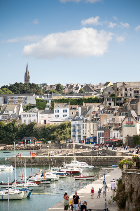 Blick auf den Hafen von Douarnenez bei Huttopia Douarnenez – Glamping Bretagne mit Booten und Häusern.