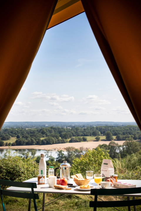 Vue depuis une tente à Huttopia Saumur - Glamping Pays de la Loire avec petit déjeuner et paysage pittoresque.