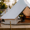 Glamping tents at Boszee in West Flanders, Belgium, featuring a wooden deck and cozy evening lighting.