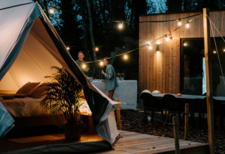 Hébergement glamping chez Boszee en Flandre-Occidentale, avec tentes élégantes, guirlandes et cabane moderne.