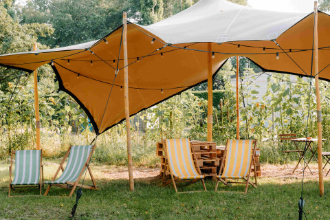 Cozy glamping tents and deckchairs at Boszee - Glampingtenten West-Vlaanderen set in a scenic outdoor area.