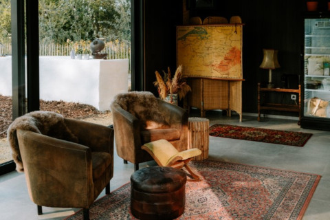 Salon de glamping confortable avec fauteuils, tapis et vue nature chez Boszee Glampingtenten West-Vlaanderen.