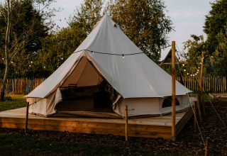 Glampingzelt auf Holzplattform mit Lichterketten bei Boszee - Glampingtenten West-Vlaanderen in der Natur.