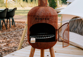 Rustieke Bonfeu buitenhaard op houten vlonder bij glampingtent in Boszee - Glampingtenten West-Vlaanderen.