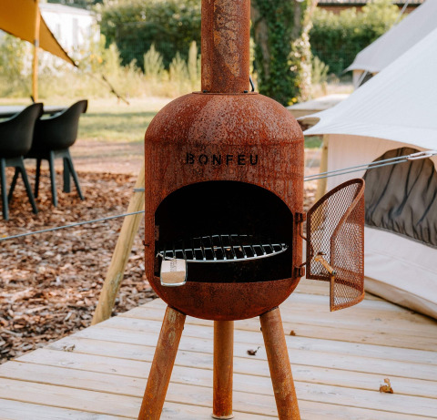 Rustieke Bonfeu buitenhaard op houten vlonder bij glampingtent in Boszee - Glampingtenten West-Vlaanderen.
