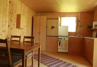 Küche einer Holz-Glampinghütte mit Esstisch bei Kano & Kamp Aqua Hema- Blokhutten Beieren in den Niederlanden.