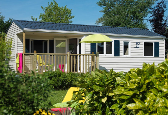 Luxuriöse Glamping-Unterkunft im Eifelidyll, Rheinland-Pfalz, mit Terrasse, Sonnenschirm und Gartenblick.