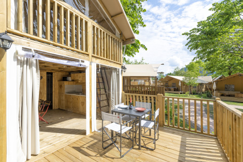 Udendørs terrasse ved Trasimeno Glamping Resort Airlodges med spisebord og udsigt til flere glampinghytter.