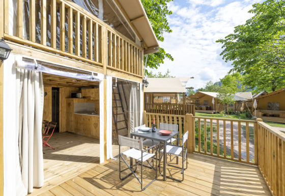 Udendørs terrasse ved Trasimeno Glamping Resort Airlodges med spisebord og udsigt til flere glampinghytter.