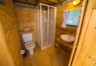 Moderne badeværelse i træ på Trasimeno Glamping Resort Airlodges med brusekabine og vindue.