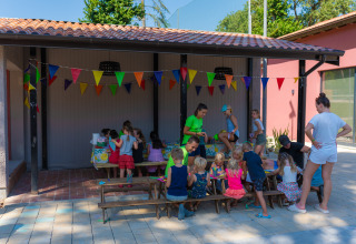 Kinder und Erwachsene machen zusammen Bastelarbeiten im Freien im Trasimeno Glamping Resort in Italien.