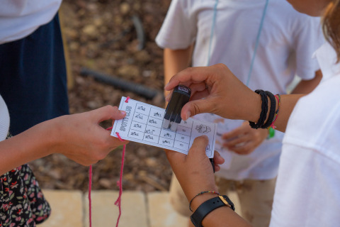 Children’s activity at Trasimeno Glamping Resort with a card being stamped, Vacanze col Cuore holiday.