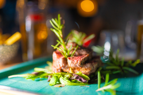 Una gustosa bistecca con erbe fresche e insalata servita al Trasimeno Glamping Resort in Umbria.