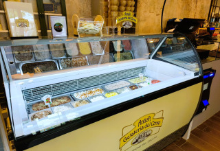 Inside an Italian gelato shop with a variety of gelato flavors and waffle cones at Trasimeno Glamping Resort.