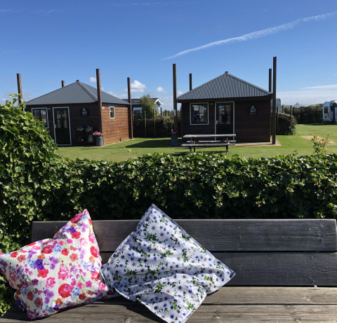 Alojamiento glamping con cabañas de madera y cojines coloridos, Camping Duinzoomhoeve, Norte de Holanda.
