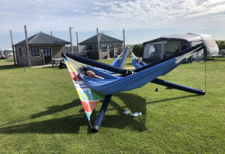 Zwei Personen entspannen in Hängematten auf dem Camping Duinzoomhoeve – Hooiberghut Glamping in Nordholland.