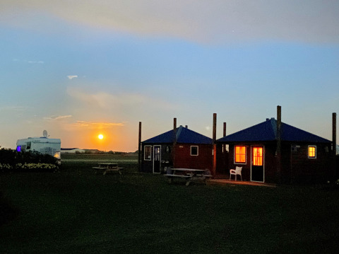 Atardecer en Camping Duinzoomhoeve – Hooiberghut glamping con cabañas y caravana en Noord-Holland.