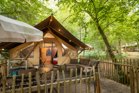 Stylische Glamping-Unterkunft mit Terrasse und Möbeln im Wald bei Huttopia Senonches, Val de Loire.