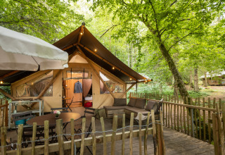 Hébergement glamping moderne avec terrasse et mobilier en pleine forêt au Village Huttopia Senonches, Val de Loire.