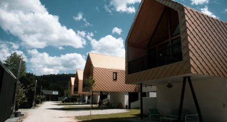 Abenteuer Camp Schnitzmühle Tiny House im Bayerischen Wald, komfortables Glamping unter blauem Himmel.