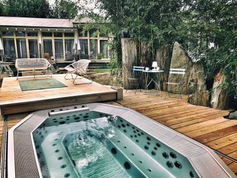 Terrasse avec jacuzzi, chaises et bambous à Adventure Camp Schnitzmühle, Tiny House Forêt bavaroise.