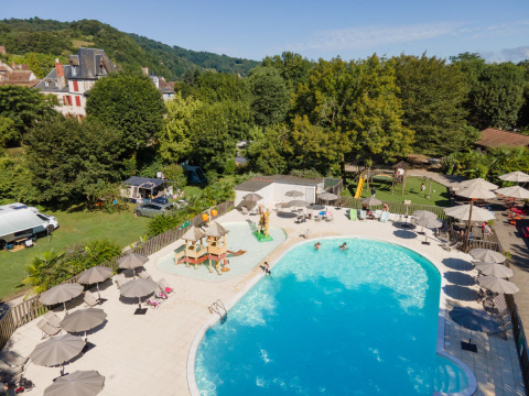 Luksuriøs campingplads Huttopia Beaulieu sur Dordogne med swimmingpool, legeområde og grøn udsigt.