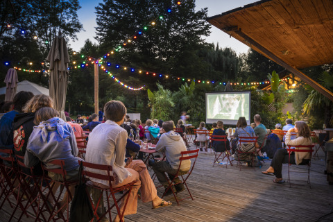 Open-Air-Kinoabend im Huttopia Beaulieu sur Dordogne, Glamping in Dordogne, Frankreich, mit Lichterketten