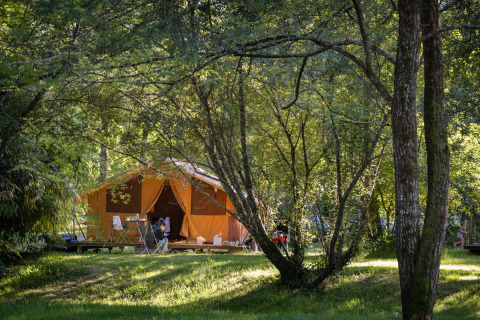Glamping chez Huttopia Beaulieu sur Dordogne, grandes tentes au cœur de la forêt verdoyante et ambiance paisible.