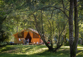 Glamping experience at Huttopia Beaulieu sur Dordogne, with large tents in a lush, wooded outdoor setting.